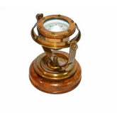 A 5-inch tall brass compass with a gimbal base, featuring an antique finish and a nautical design, ideal for maritime navigation or as a decorative piece.